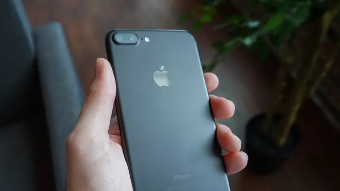Hand hält ein Smartphone zur Übergabe bereit